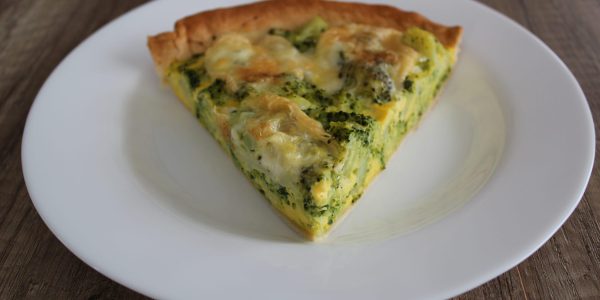 Part de quiche au brocolis et munster sur assiette blanche