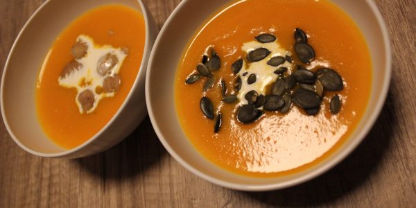Bol avec de la soupe de potimarron, un bol avec des graines de courges, l'autre avec des brisures de marrons